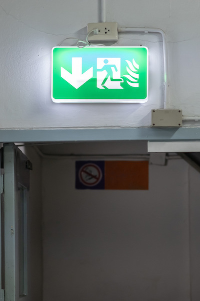 Fire Emergency Exit light box sign setup over exit door in the old building.